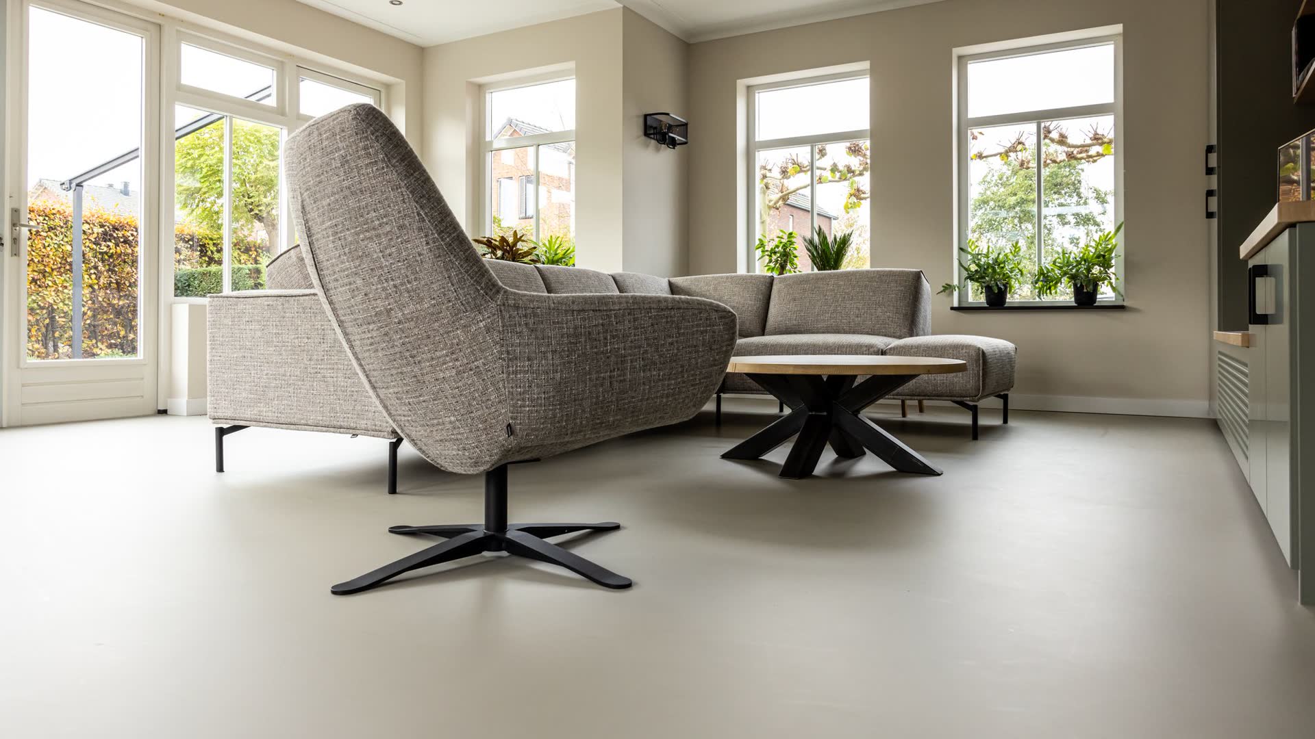 Ruime woonkamer met een naadloze PU gietvloer, compleet gestyled