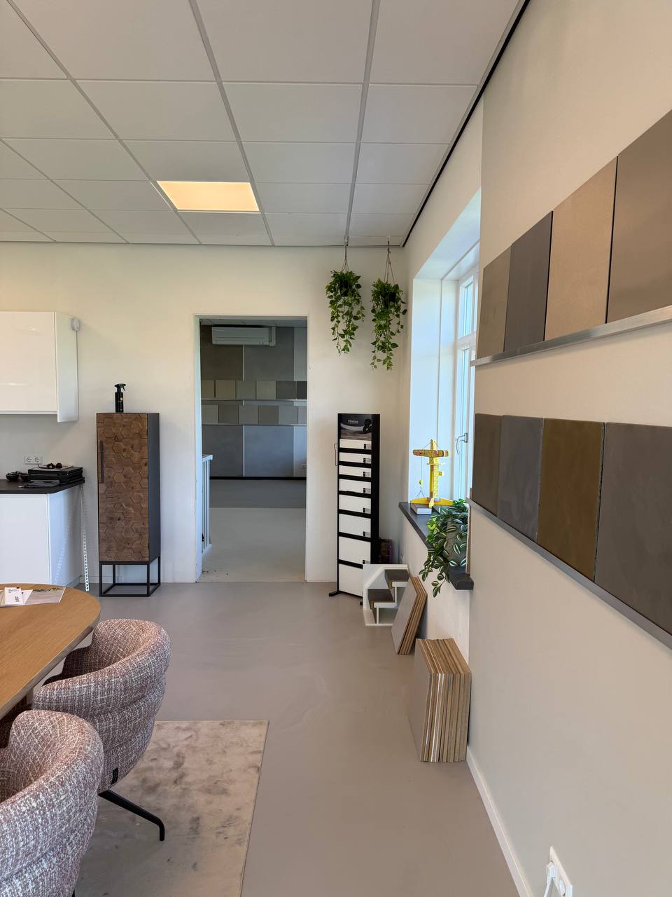 Grote stalen aan de wand in onze showroom, met doorkijk naar de volgende ruimte