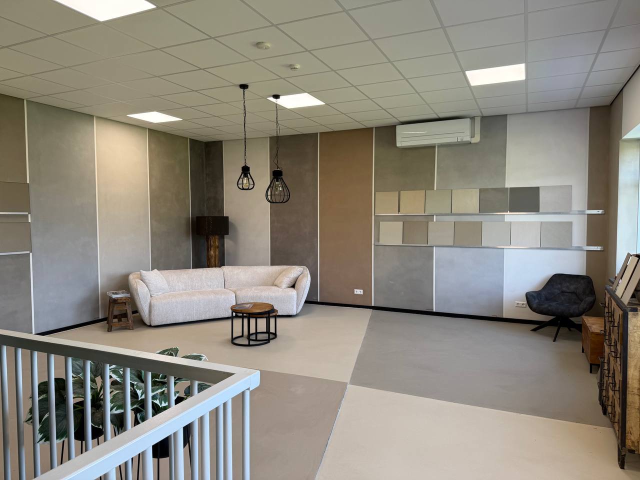 Beton ciré wandpanelen en een loungehoek in onze showroom