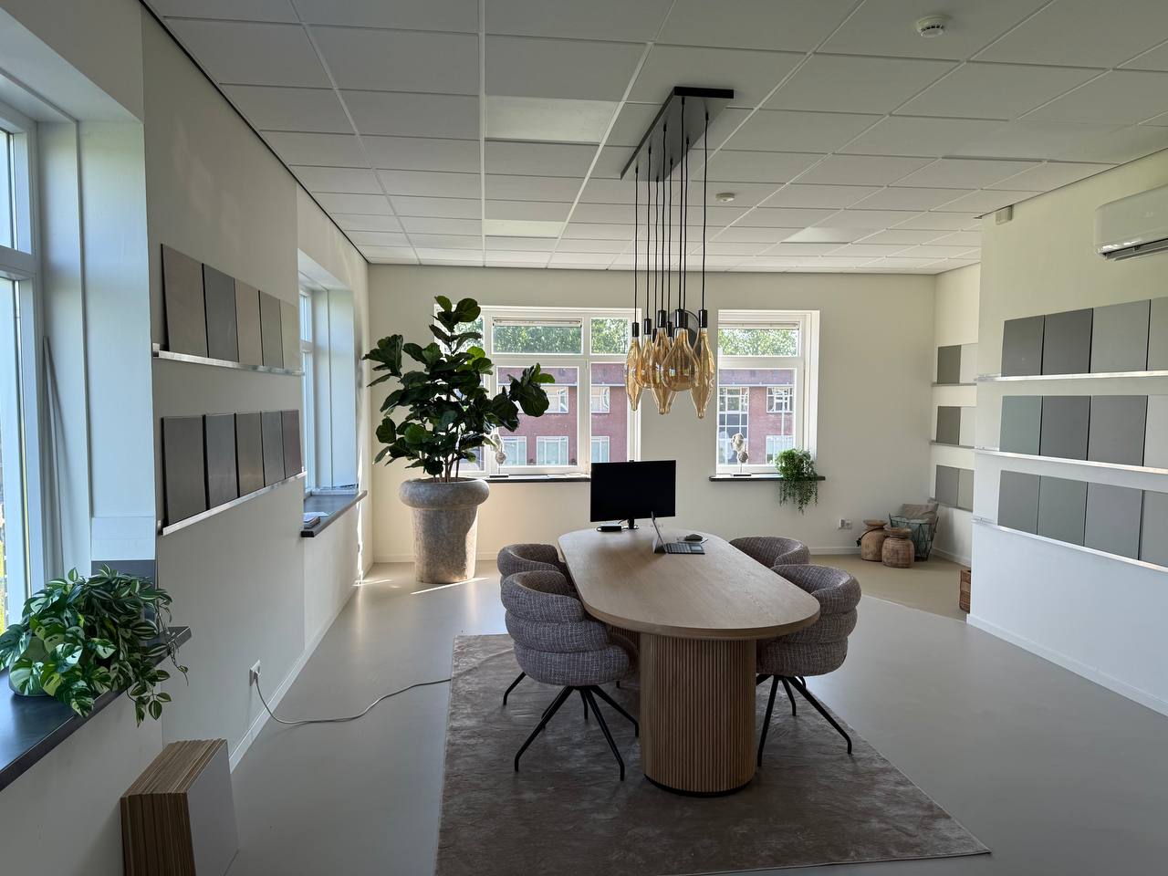 De ruime showroom van Concept Vloeren in Culemborg met een grote adviestafel, stalen aan de wand en veel daglicht